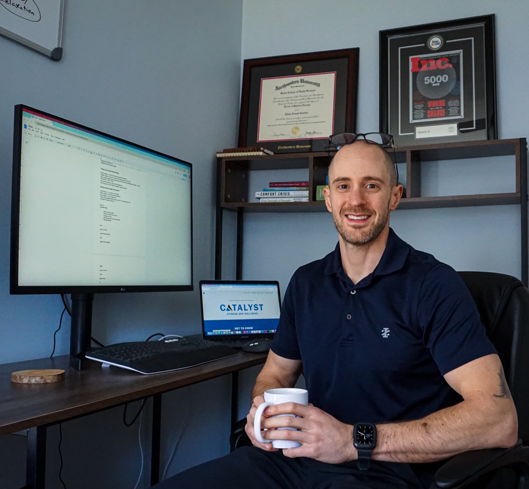 Dr. Phil Gauthier at his desk with his credentials on the wall